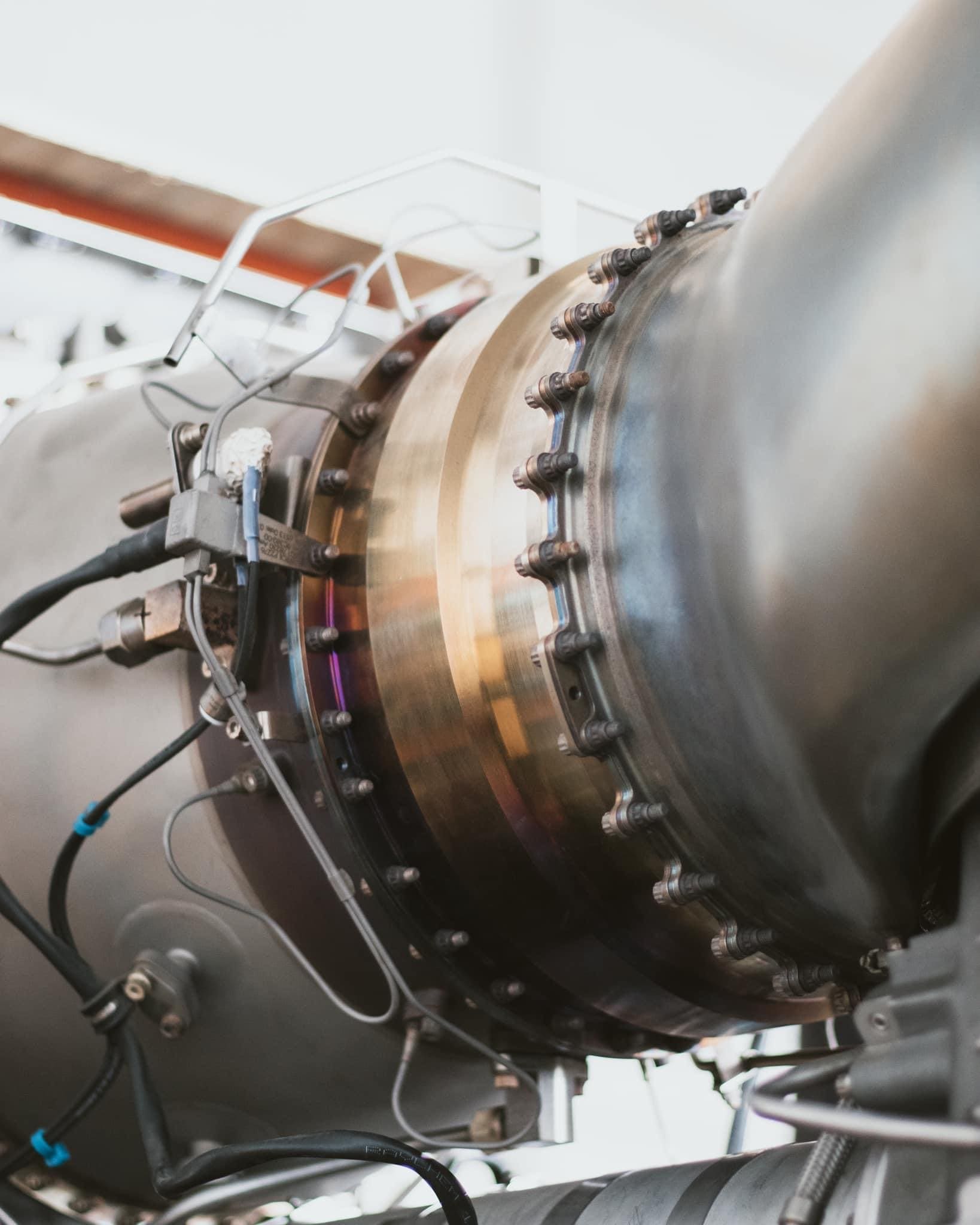 Close-up of a Safran Arriel turbine section at the Franconaves shop, heat-tinted metal and the bolted joint in focus